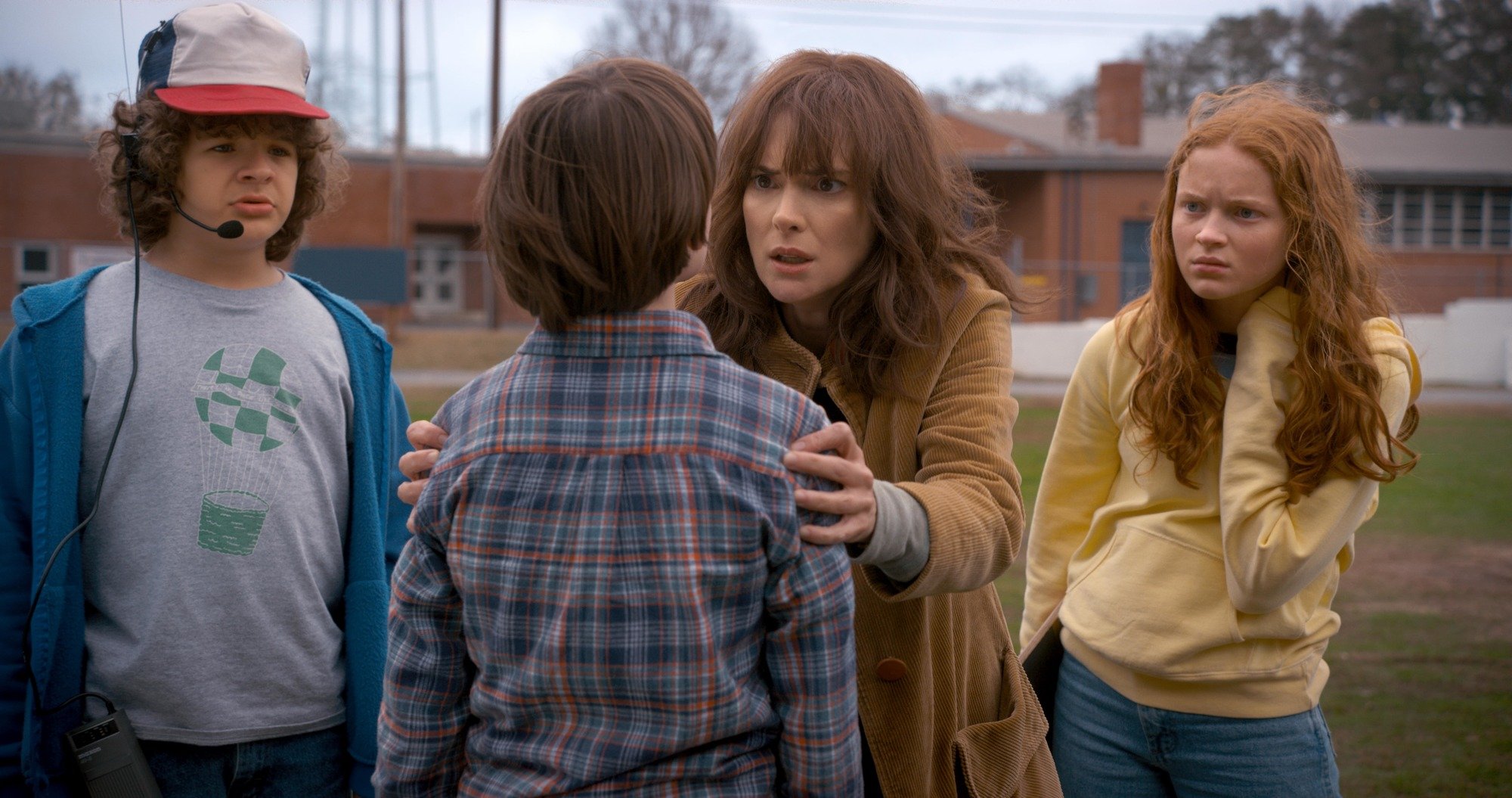 A still of Winona Ryder as Joyce from Stranger Things with the cast with her hair worn textured and with bangs