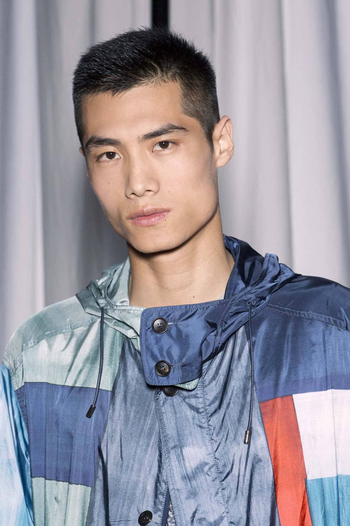 Vintage hairstyles for men: Close up shot of a man with dark brown hair styled into a high and tight short haircut backstage