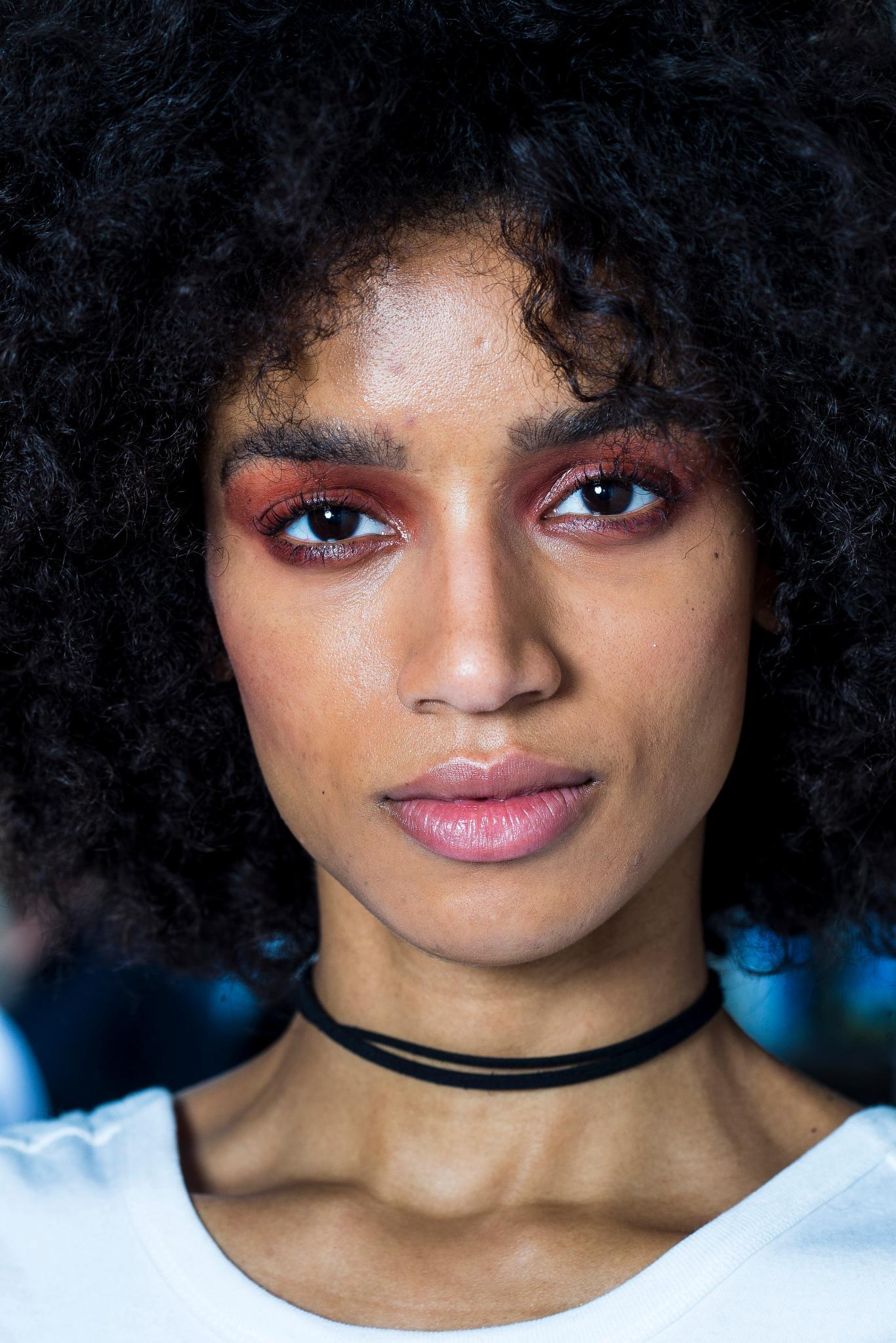curly hair type quiz: close up shot of woman with 4a curly hairstyle with choker