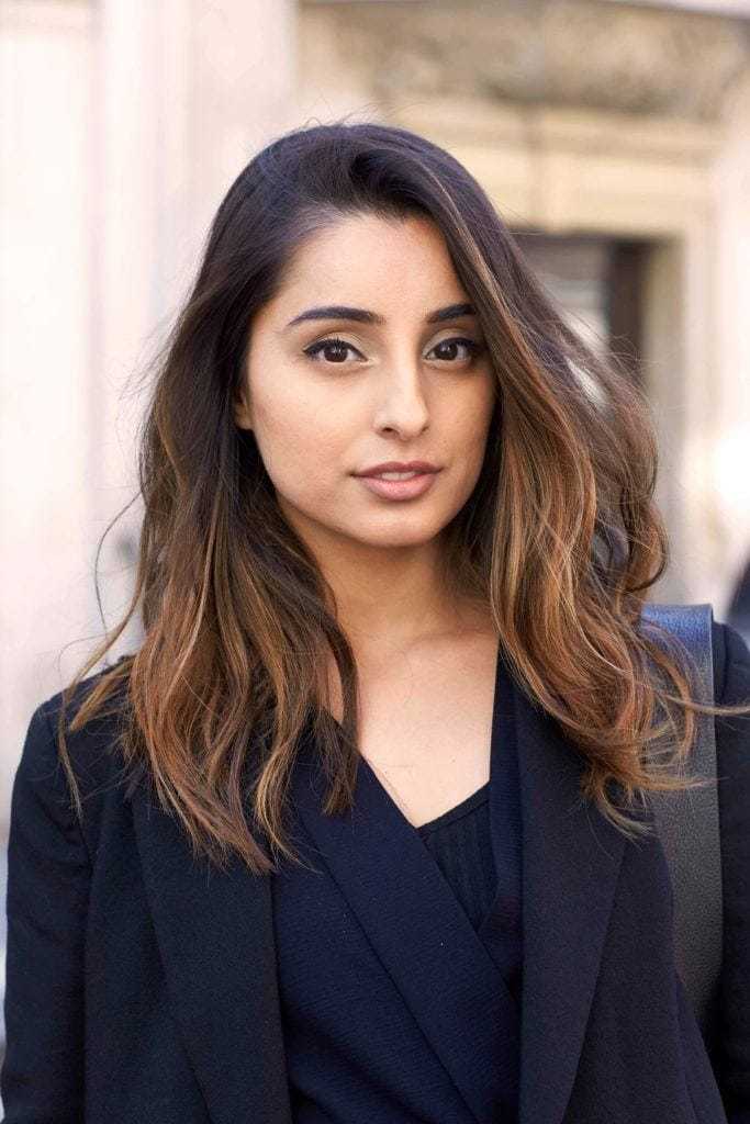 Balayage technique: Woman with medium length dark brown hair with balayage finish wearing a dark jacket.