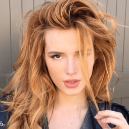 close up shot of bella thorne with copper hair, posing outside