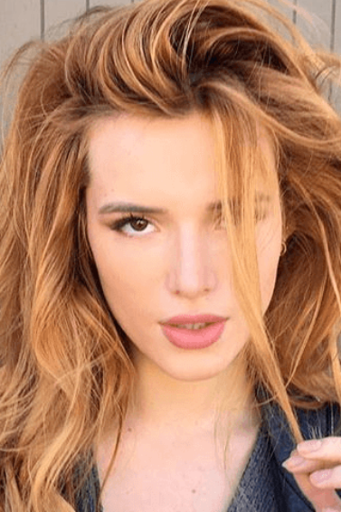 close up shot of bella thorne with copper hair, posing outside