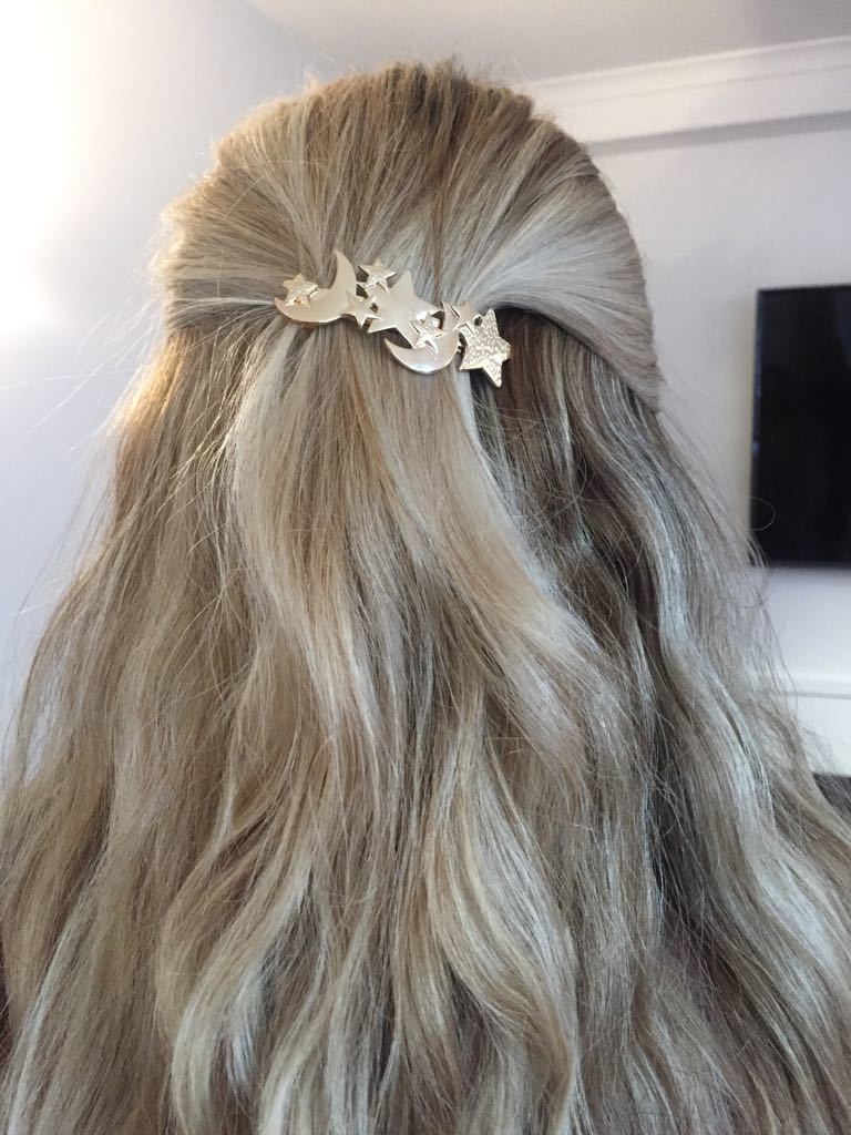 back view of beth with blonde half-up, half-down wavy hair with star hair trend slide