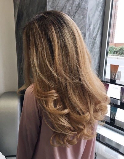 back view of a woman with brunette curly blow dried hair