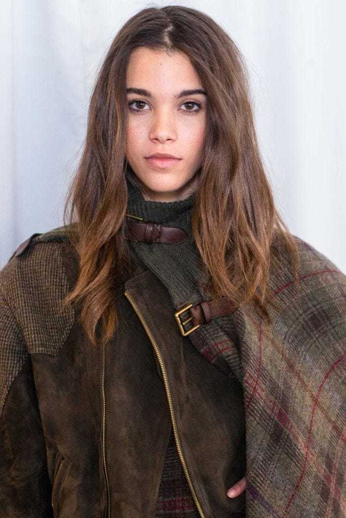 Balayage technique: Woman with dark brown medium length balayage hair wearing a checked coat.