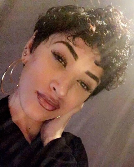 selfie of a woman with a curly permed pixie cut