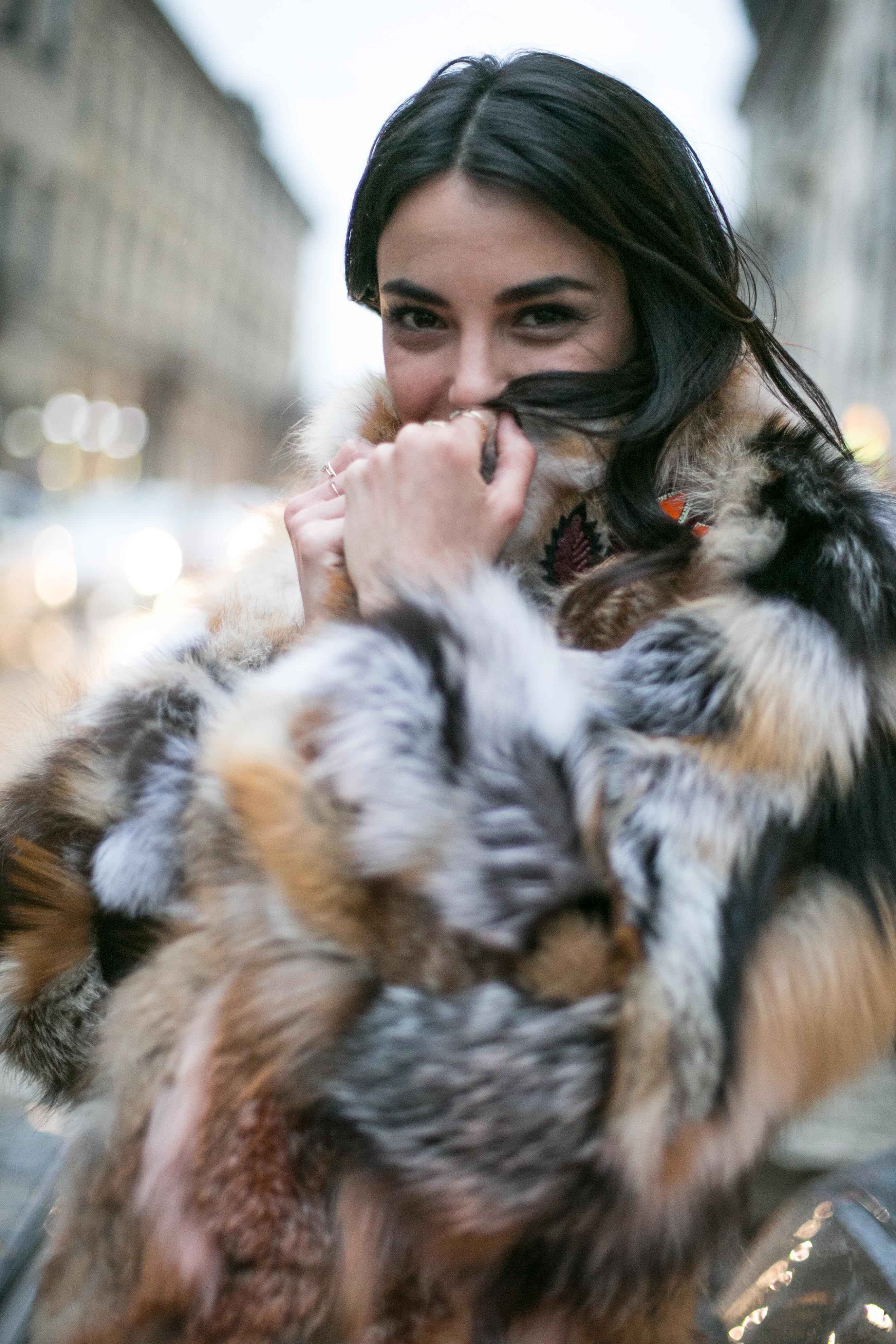 close up shot of woman with black hair, wearing faux fur jacket