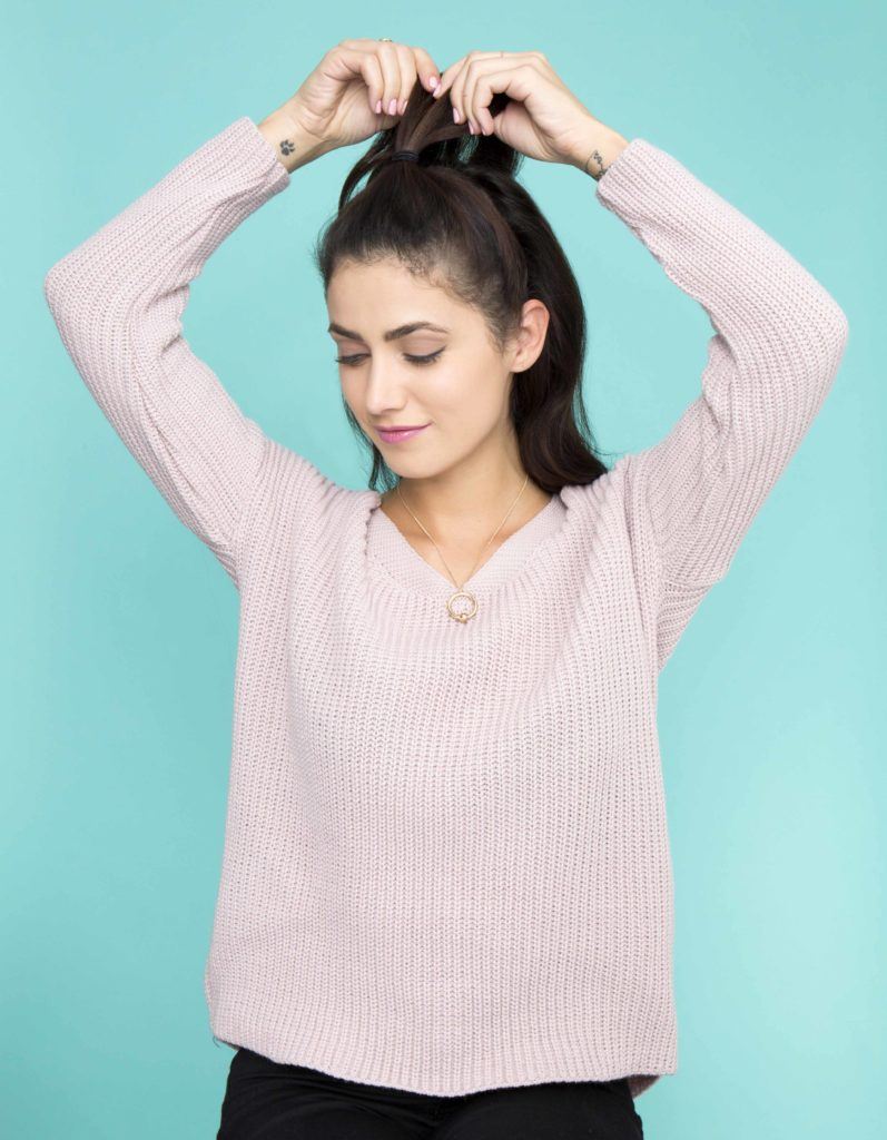 brunette model putting hair into half-up updo