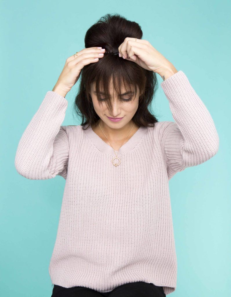 front view of brunette model with hair in updo and ends styling into bangs