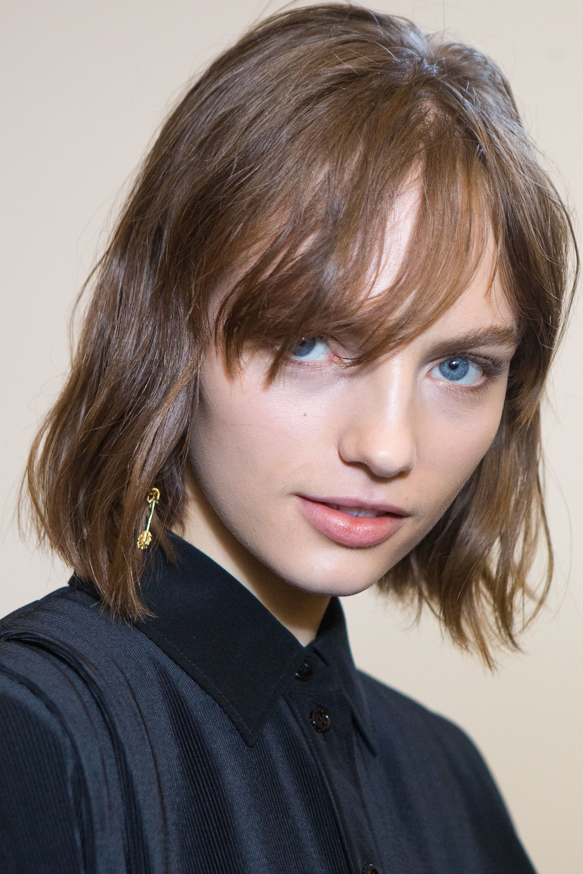 close up shot of woman with wavy hair with fringe with a black tshirt