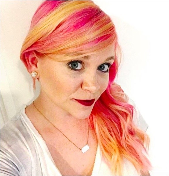 selfie of a woman with yellow and pink fruit salad inspired hair