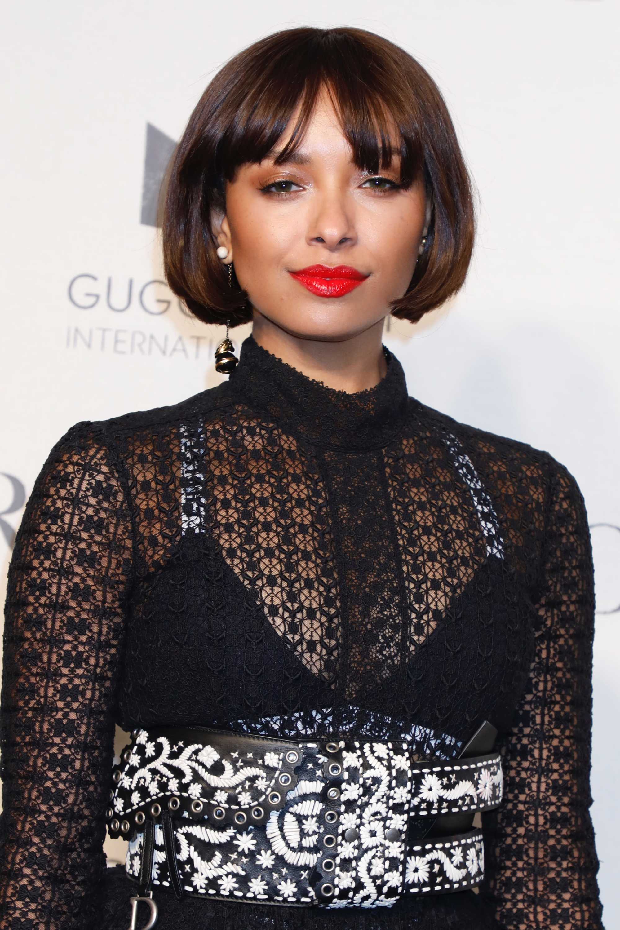 Kat Graham with iced chestnut brown hair, wearing black netted top on the red carpet