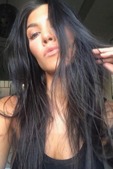 front view of kourtney kardashian selfie picture with long dark brown hair over face
