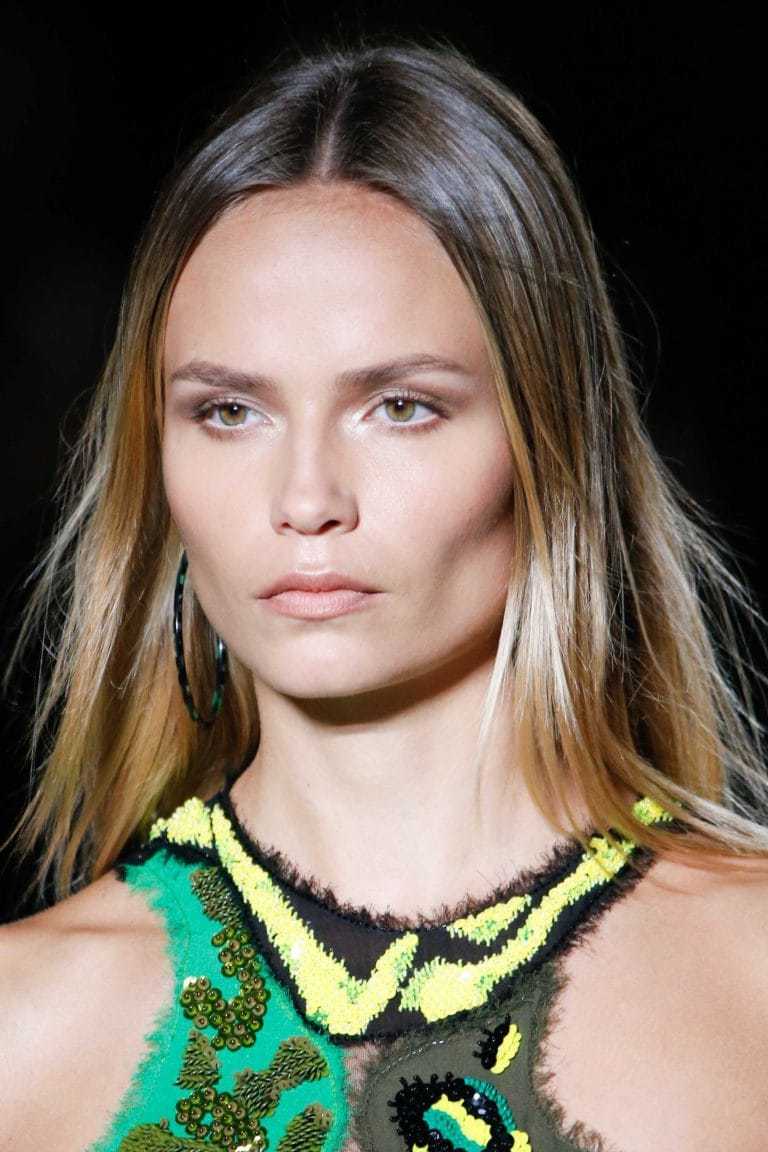 Balayage technique: Woman on runway with straight brown blonde balayage hair wearing a green dress.