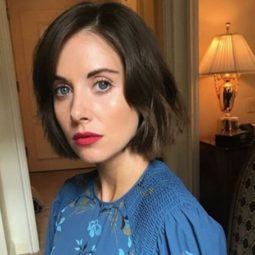 close up shot of alison brie with short hairstyle with blue denim dress, wearing red lipstick