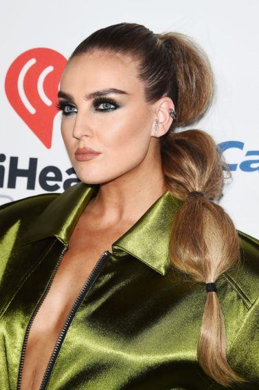 little mix singer perrie edwards in a green silky bomber jacket with her bronde hair in a side bubble ponytail