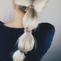 blonde woman with a bubble pony wrapped in ribbon hair ties