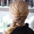 back view of a blonde woman with a side braid