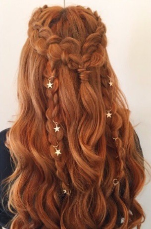 back view of a redhead woman with her hair in braids with star hair rings