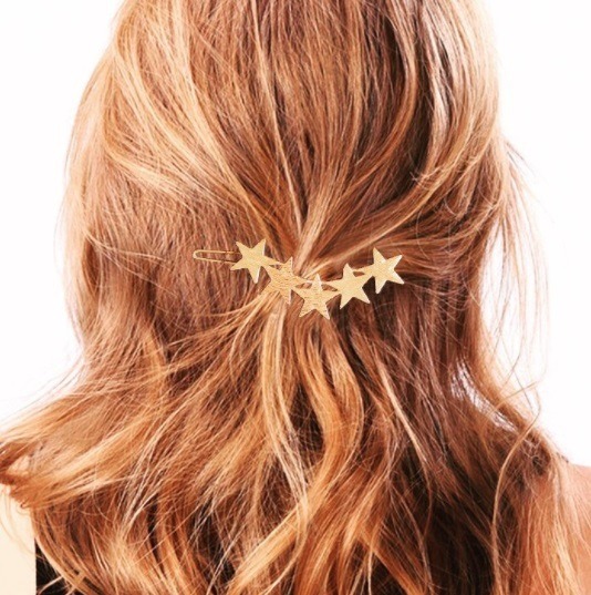 bronde woman with her hair in a half up half down hairstyle secured with a starry hair clip