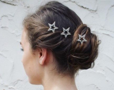 side view of a brunette woman with her hair in a twisted updo with star hair accessories