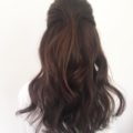 back view of a woman with dark brown hair in a swept back half up do