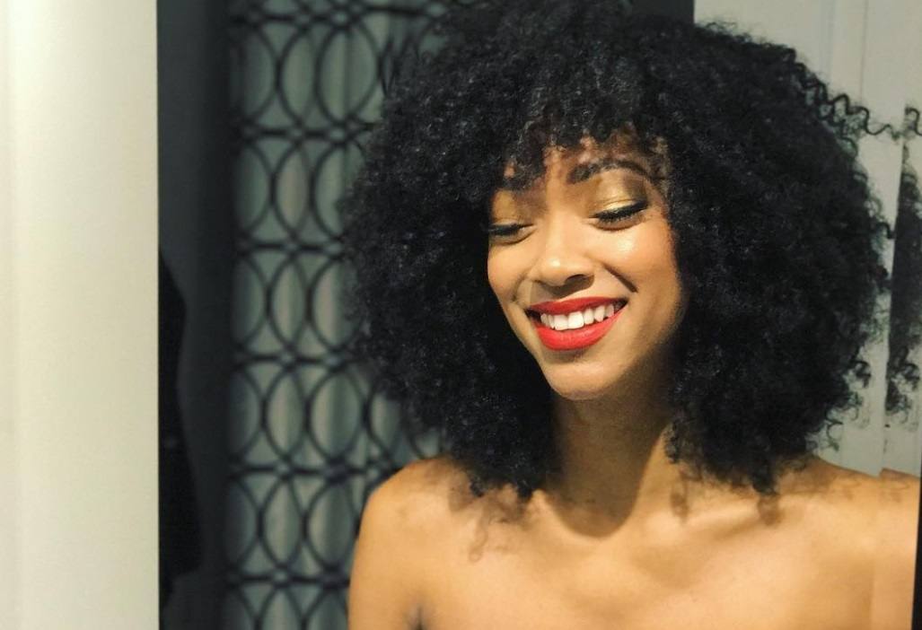 close up shot of sonequa with curly hair with bangs, smiling, instagram picture