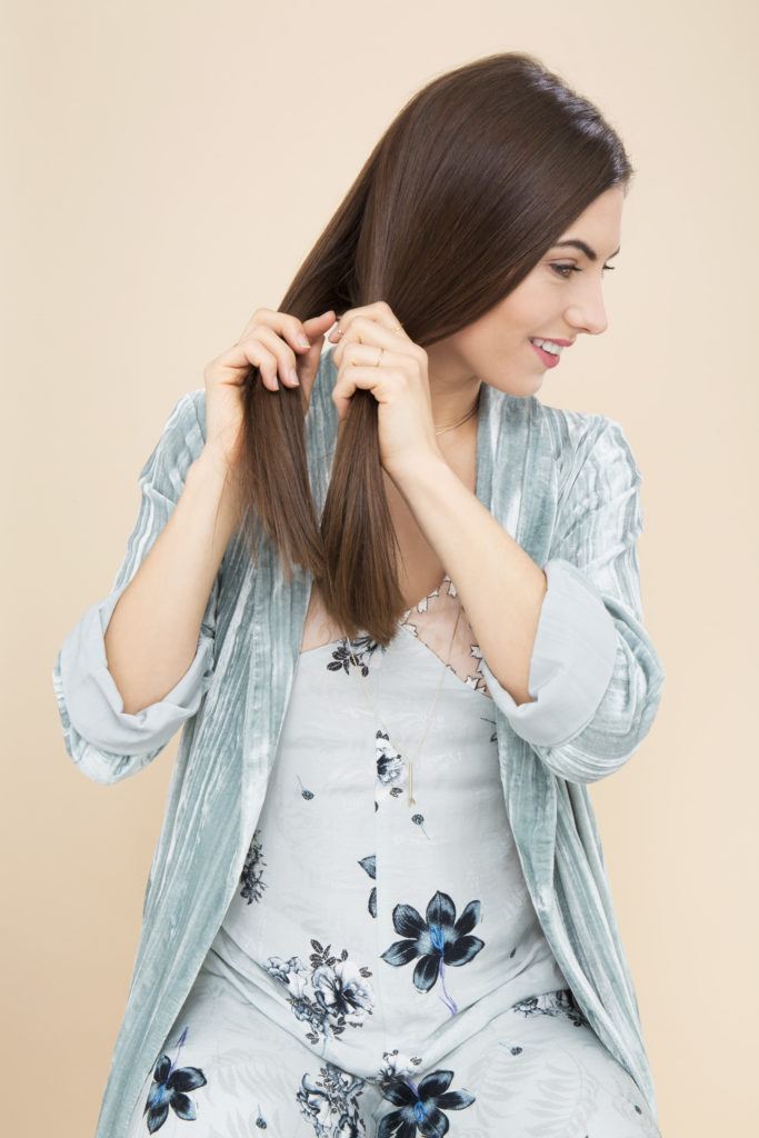 How to fishtail braid: Woman in a studio about to fishtail braid her hair in a studio setting