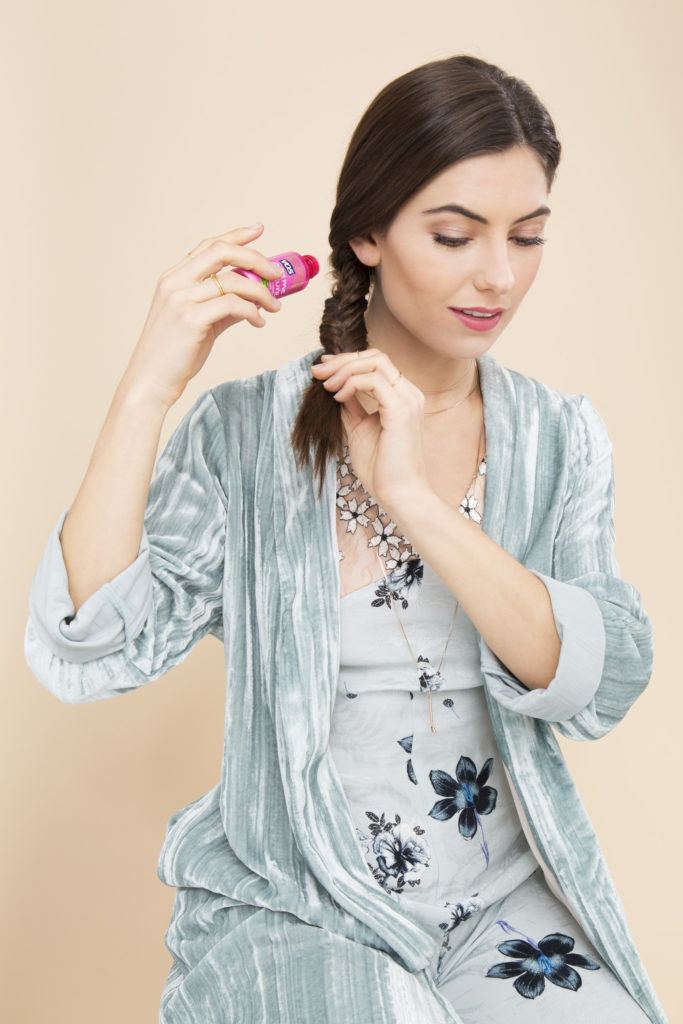 Fishtail braid how-to: Shot of woman with a fishtail braid, sprinkling volumising powder on her braid