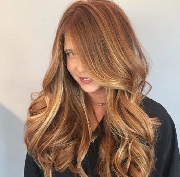 Spiced cider hair: Woman with light brown hair, with honey and spice toned highlights running through her long waves