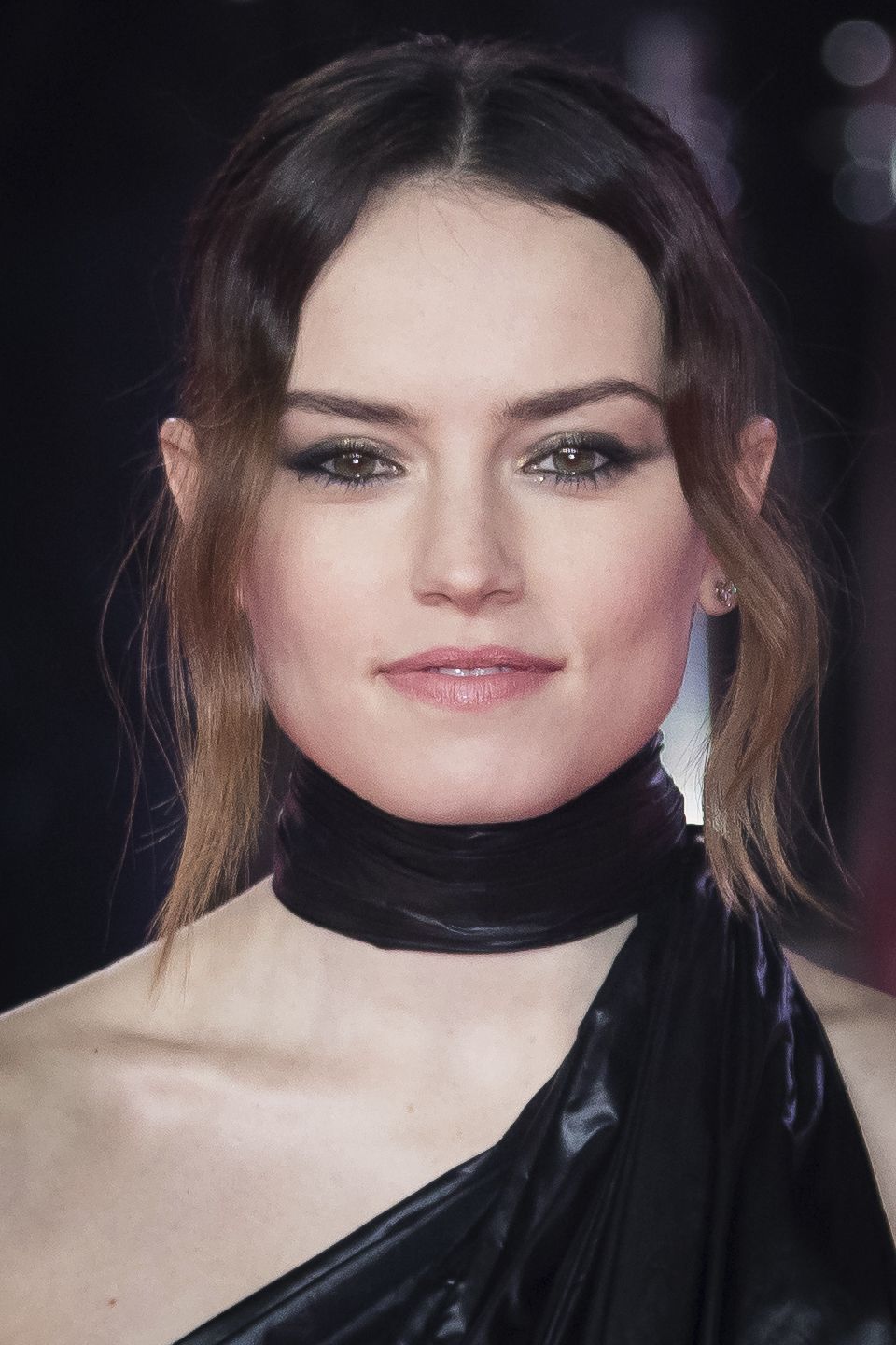 front view of daisy ridley with brown ombre hair in updo with loose long fringe