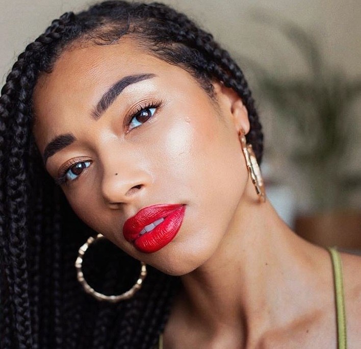 Close up of blogger freshlengths with small box braids swept to the side, wearing red lipstick and gold hoops