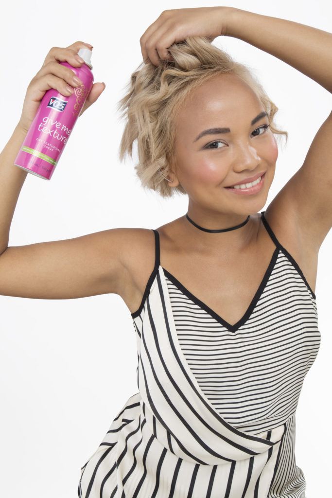 How to curl short hair blonde girl using texturising spray looking at camera