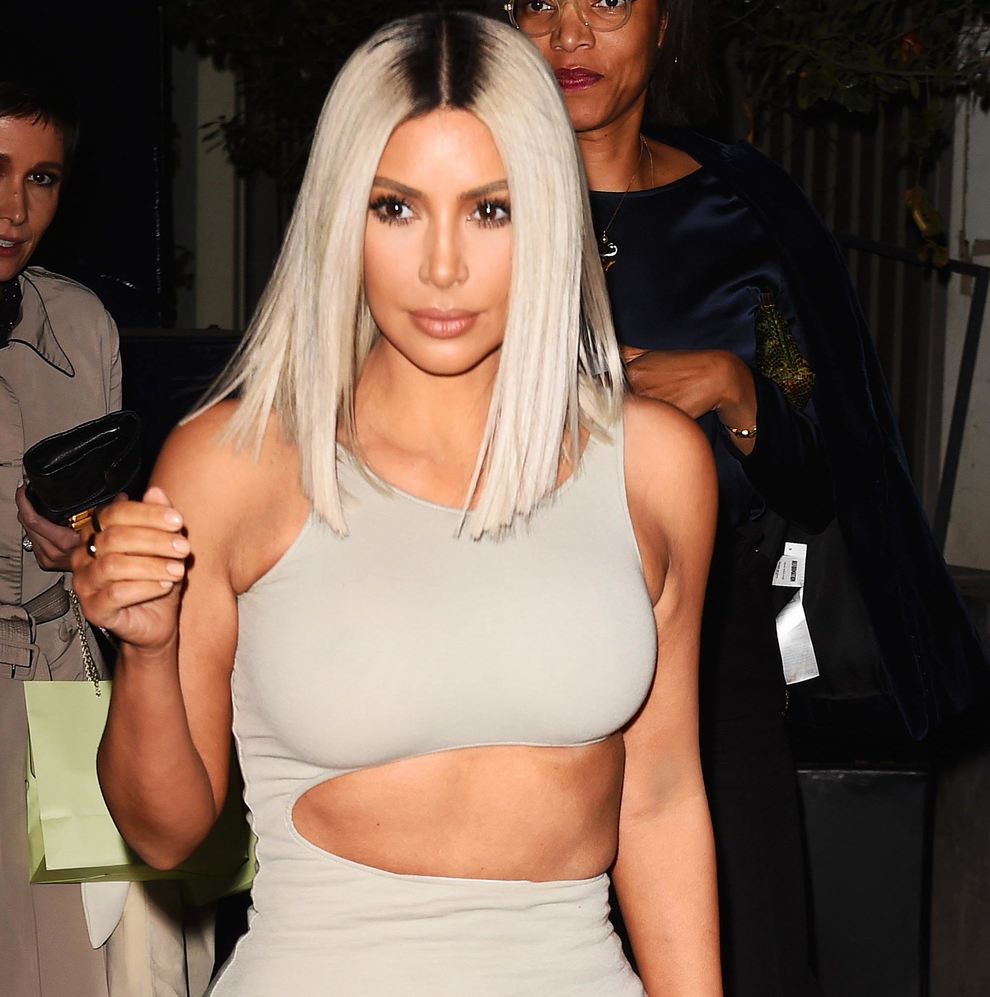 close up shot of kim kardashian west with platinum blonde blunt haircut, wearing cutout dress, leaving an event