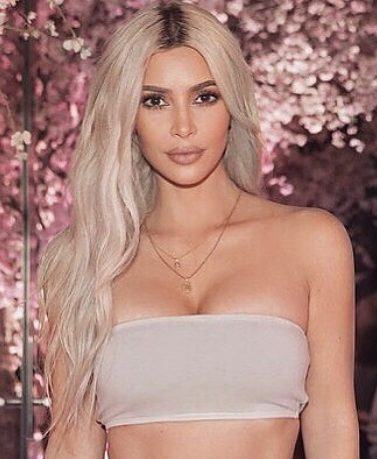 close up shot of kim kardashian west with platinum blonde hair colour, wearing bandeau top, at her cherry blossom baby shower