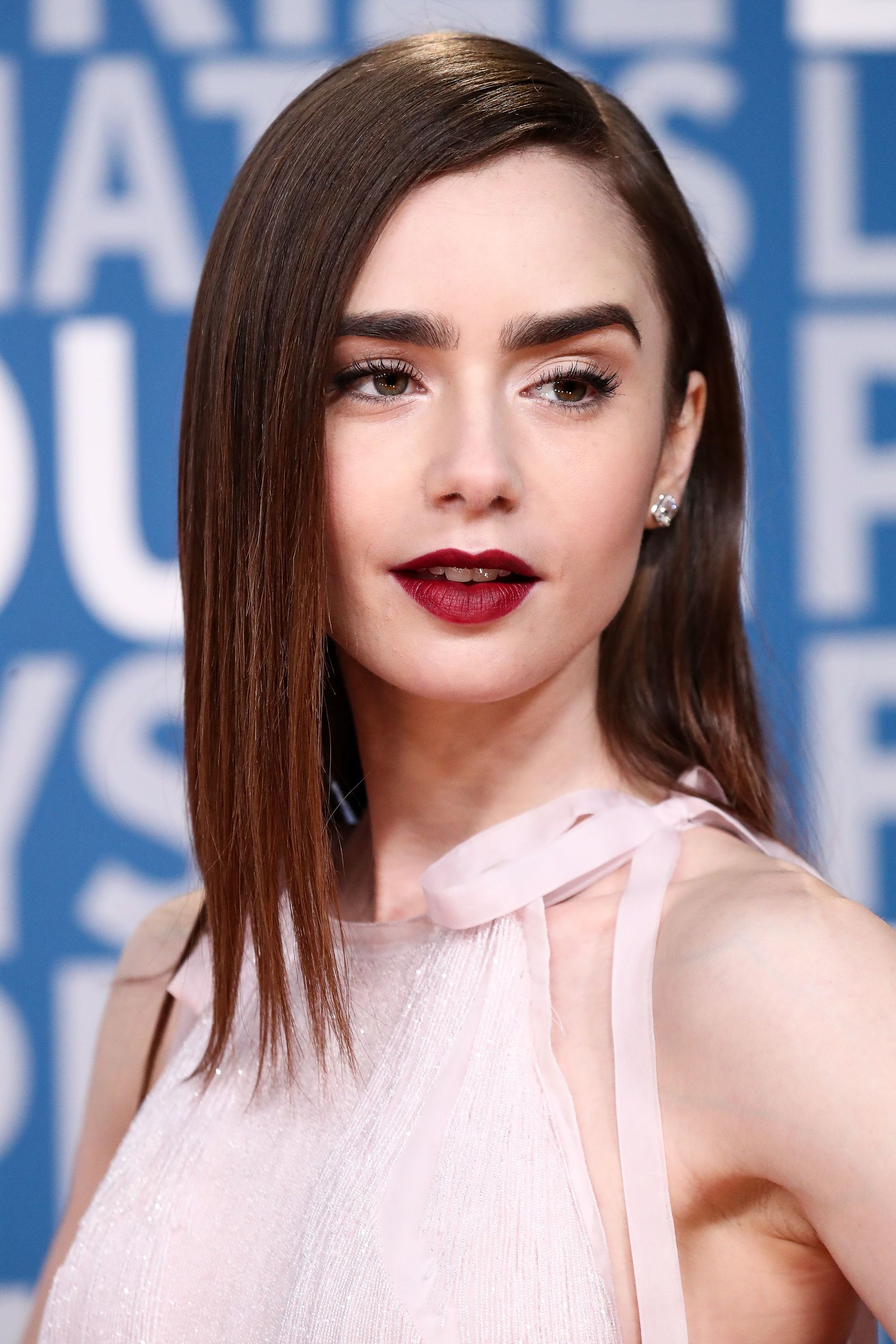 Lily Collins medium length auburn hair straight side parting