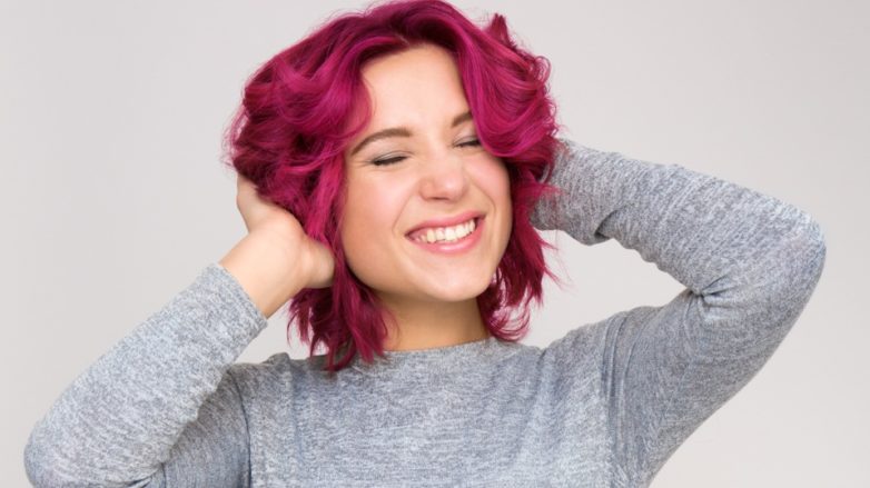 How to make short hair wavy tutorial: Girl with red hair spraying heat protector