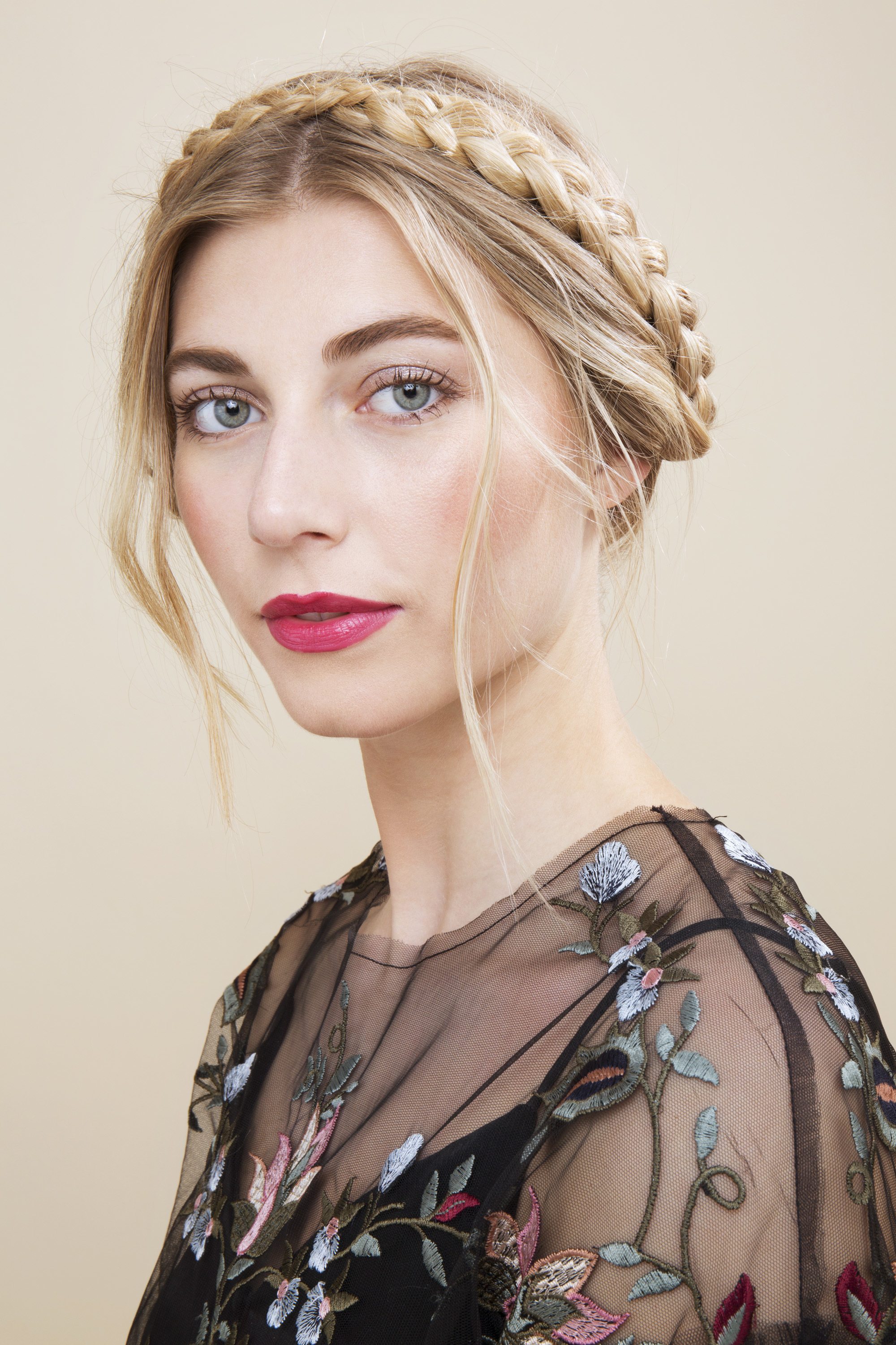 blonde model with hair in milkmaid braids and loose tendrils falling around hairline