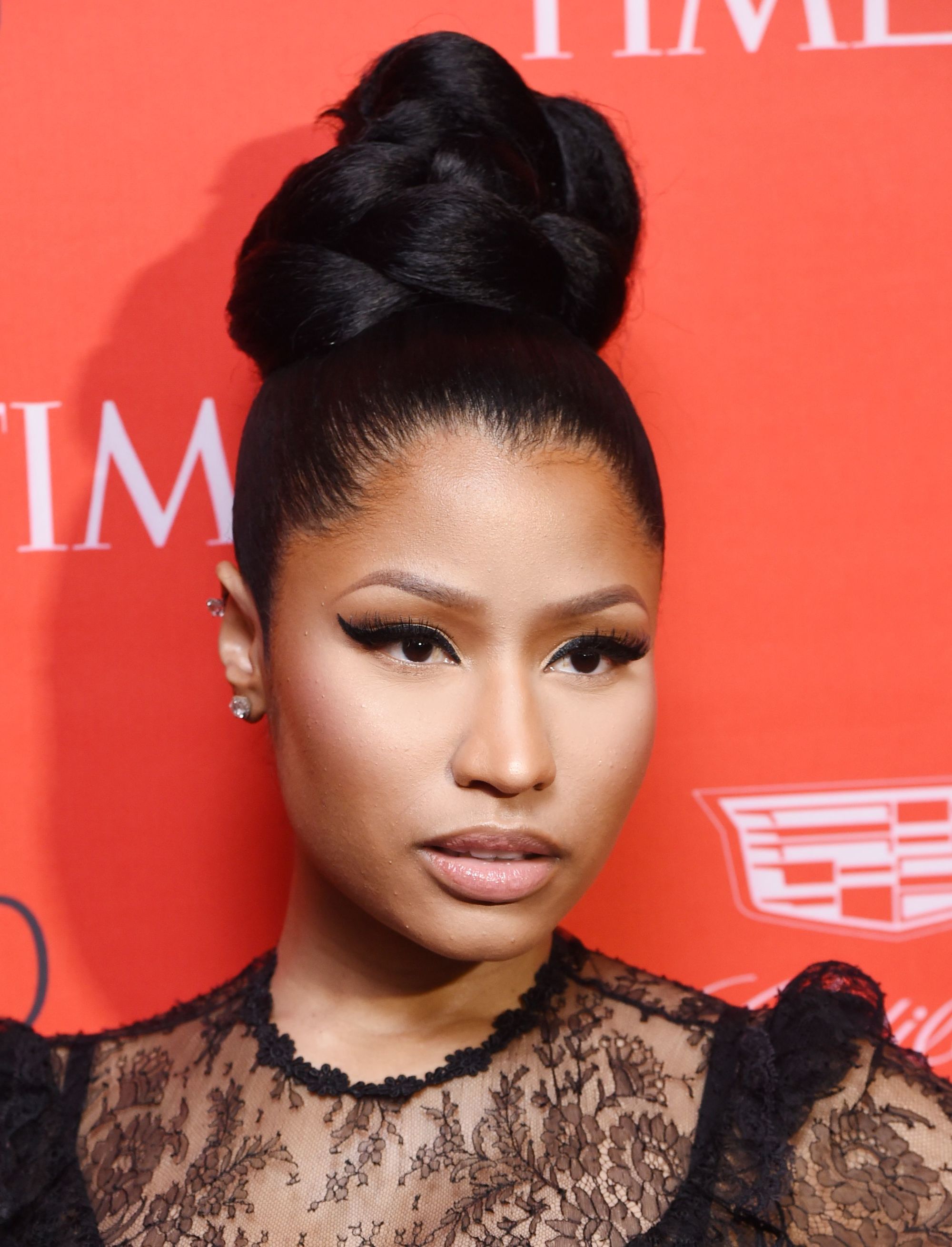 front view of Nicki Minaj with dark hair in high braided bun updo