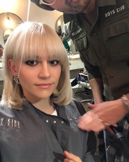 selfie from pixie lott's instagram of her in the hairdressers with a short blonde bob with a full fringe
