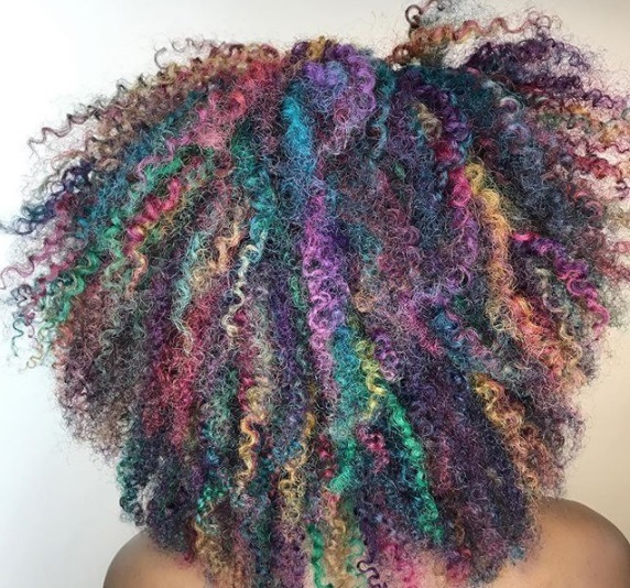 close up shot of woman with colourful natural hair ombre hairstyle, in a salon