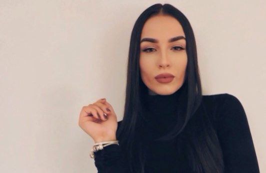 photo of a woman wearing a black roll neck with her long dark hair straight and sleek