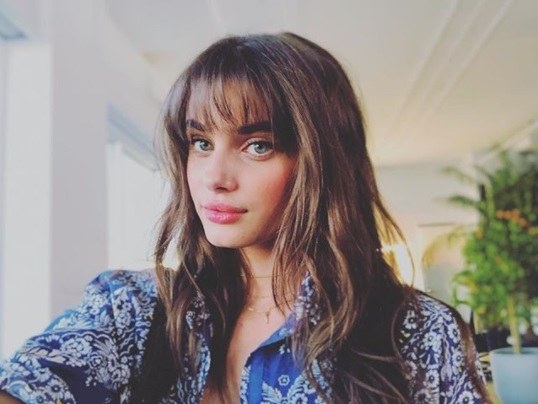 taylor hill with long brunette wavy hair and full birkin bangs
