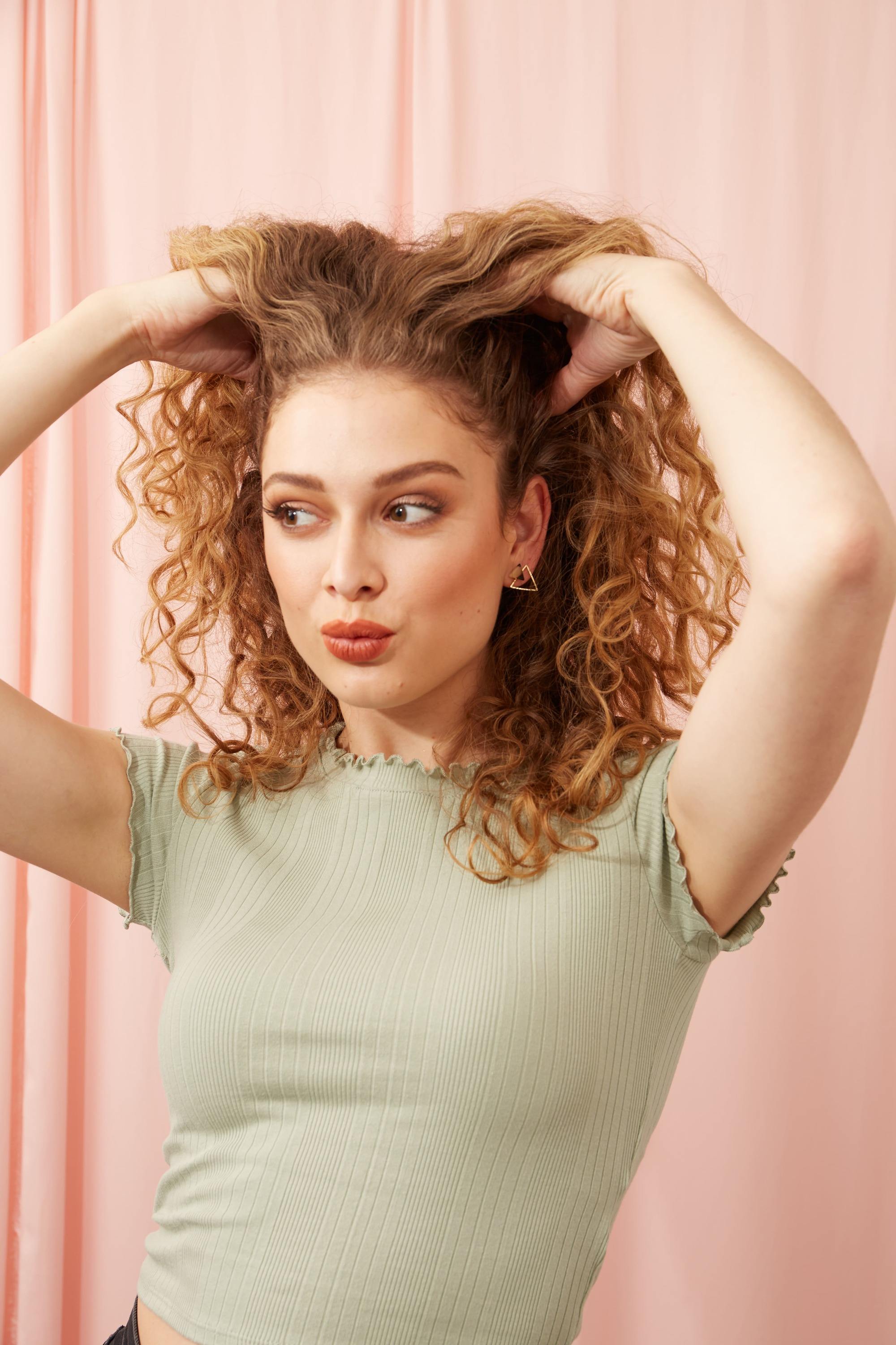 Woman touching her curly blonde hair