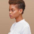 2019 haircut predictions: Woman with golden brown naturally curly short hair styled with a mohawk.
