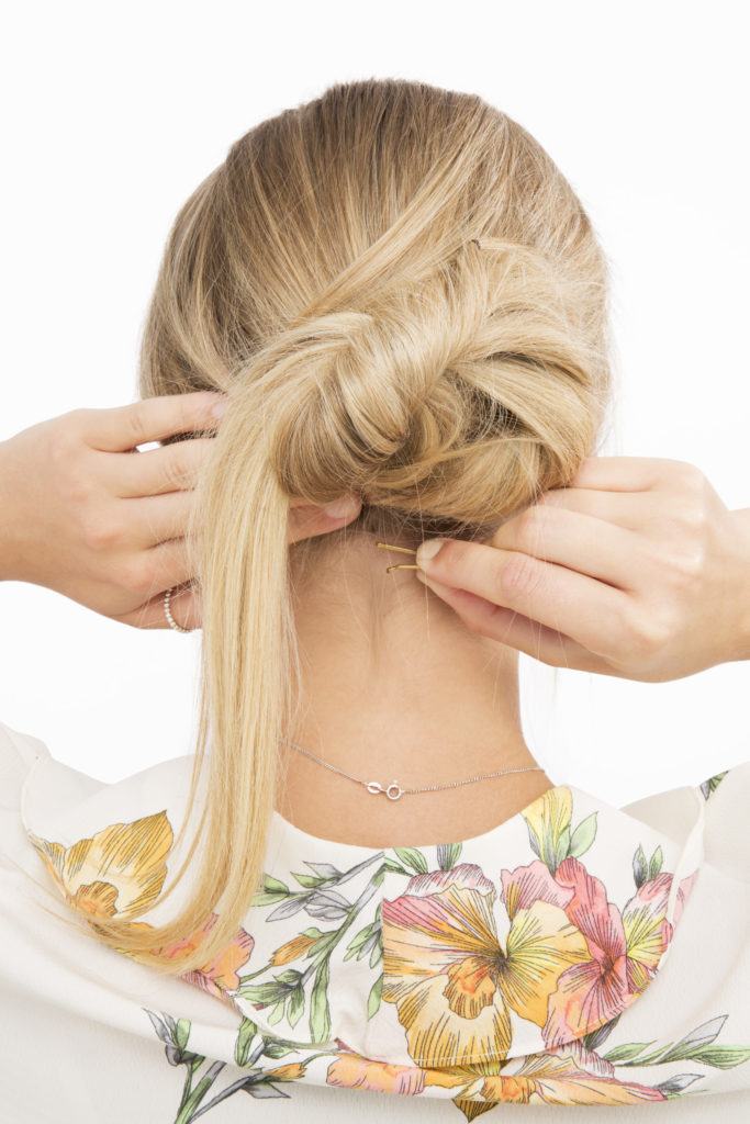 Banana bun tutorial blonde girl twisting hair into bun