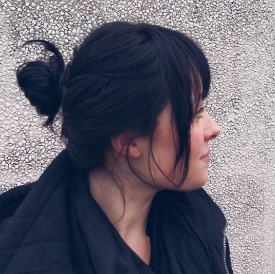 side profile of a woman with black hair in a bun