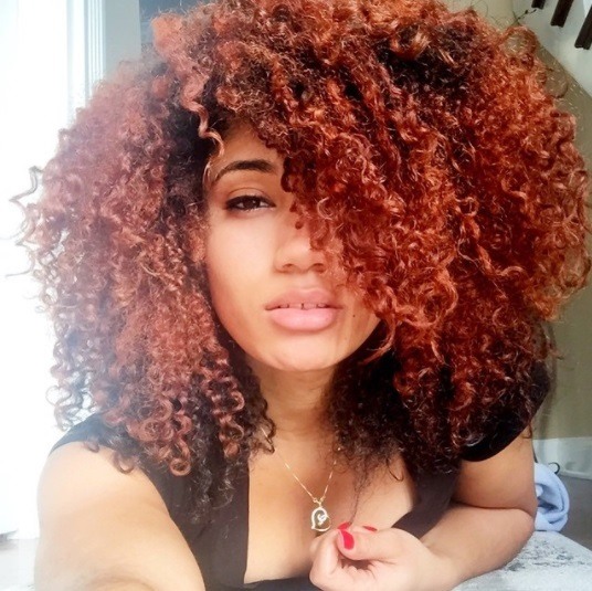 woman with curly natural hair dyed auburn