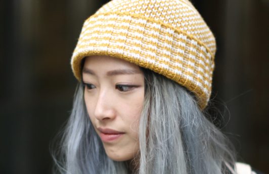 Best deep conditioner for damaged hair: Woman with grey long hair under wolly hat street style.