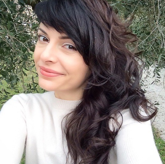 woman with dark ebony curled long hair